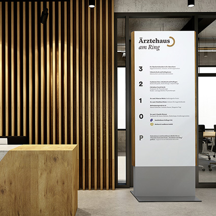 Innenaufsteller (Infostele) aus Holz in einem Durchgang am Empfang Innenaufsteller (Infostele) aus Holz in einem Durchgang am Empfang