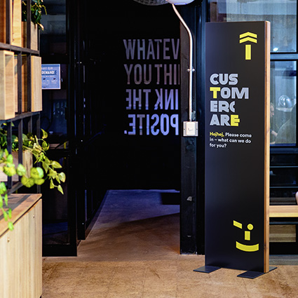 Innenaufsteller (Infostele) aus Holz in einem Durchgang in Schwarz Innenaufsteller (Infostele) aus Holz in einem Durchgang in Schwarz